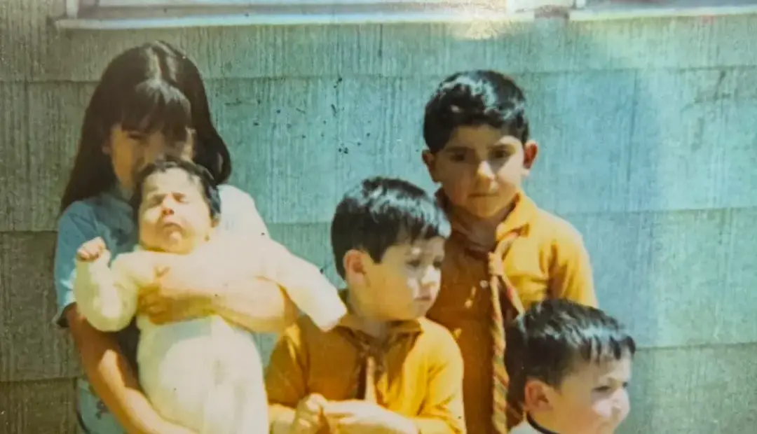 Siblings gathered together outside a family home